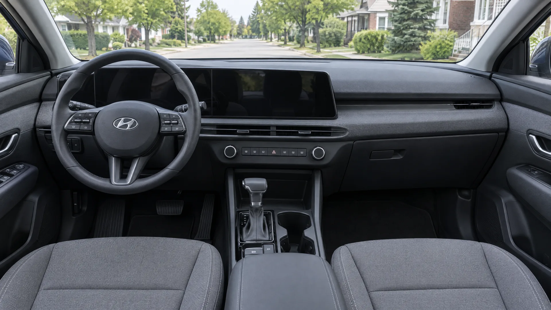 Habitacle d'un Hyundai Tucson 2026 vu depuis le siège passager, écrans en veille, sellerie grise