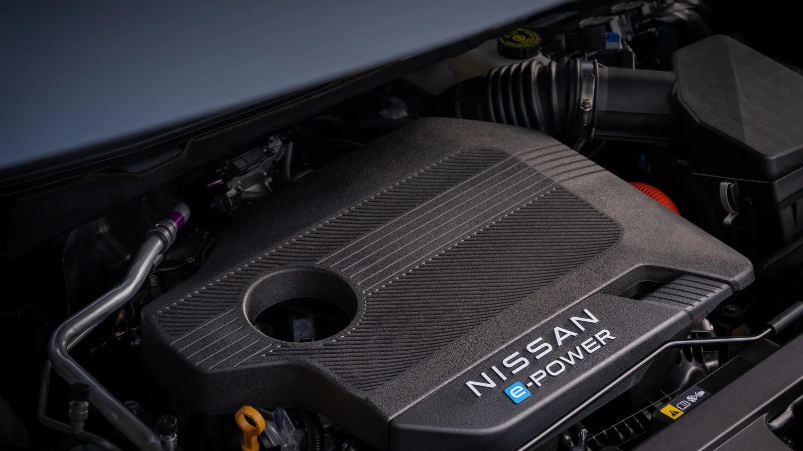 Compartiment moteur du Nissan Rogue hybride 2027 : cache-moteur noir portant les mots Nissan et e-POWER