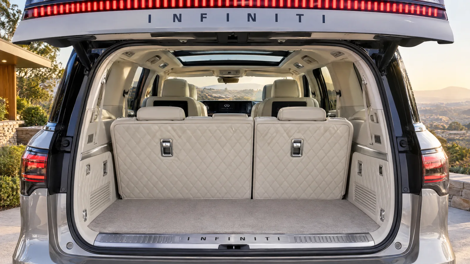 Troisième rangée d'un INFINITI QX80 2026 vue par le hayon ouvert, sellerie claire matelassée, banquette relevée