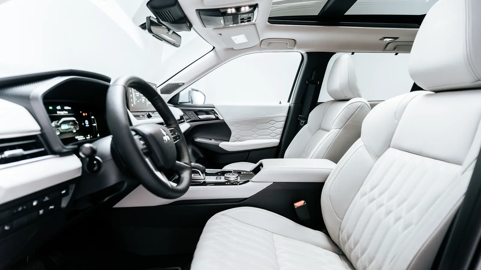 Habitacle en cuir blanc d’un Mitsubishi Outlander PHEV 2026, volant et sièges avant vus depuis la banquette arrière.